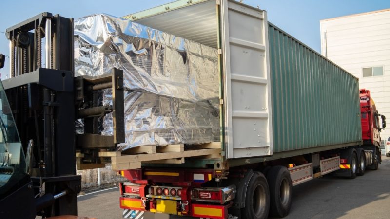 loading cargo into a container on a big trailer truck with a folk lift